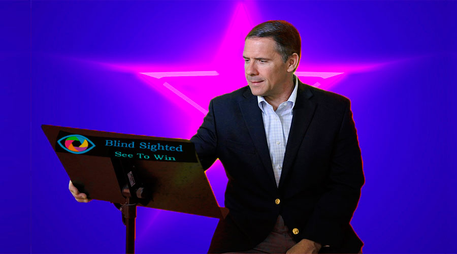 Charlie Collins speaking at a keynote engagement with a blue backbround.